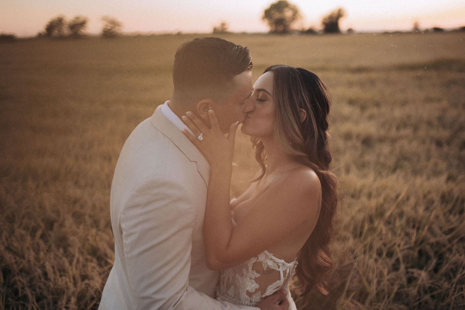 Bride and groom walking together in a wide-open Idaho field at sunset