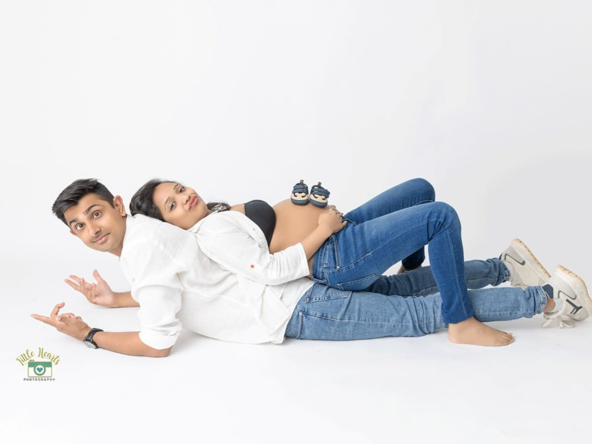 Side view of person lying down in casual white shirt and blue jeans on plain white background.
