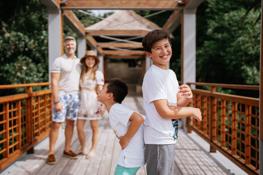 A candid family moment captured on a covered wooden bridge walkway.