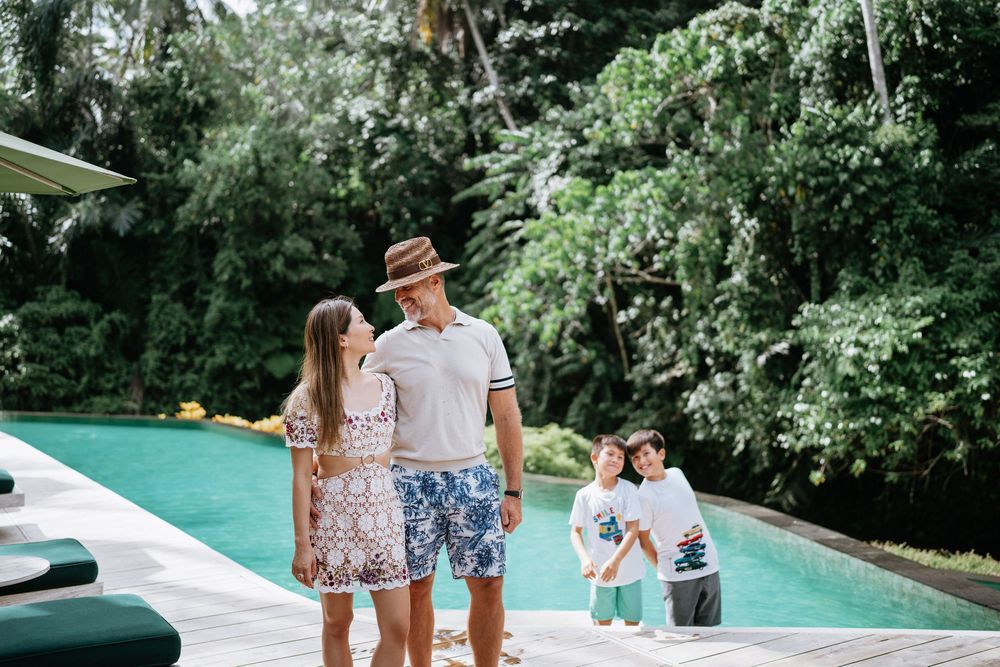 Couples enjoying a relaxing moment by an infinity pool surrounded by lush tropical gardens.
