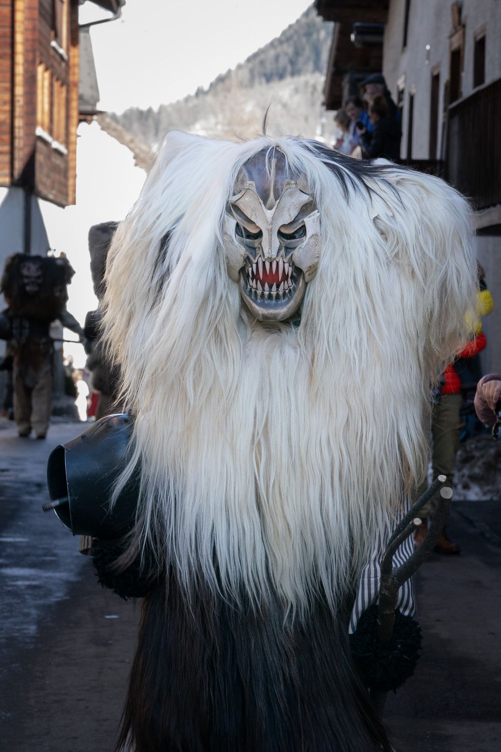 Traditional Alpine Krampus mask with long white fur and demonic features worn during winter folklore festivals in Austria.