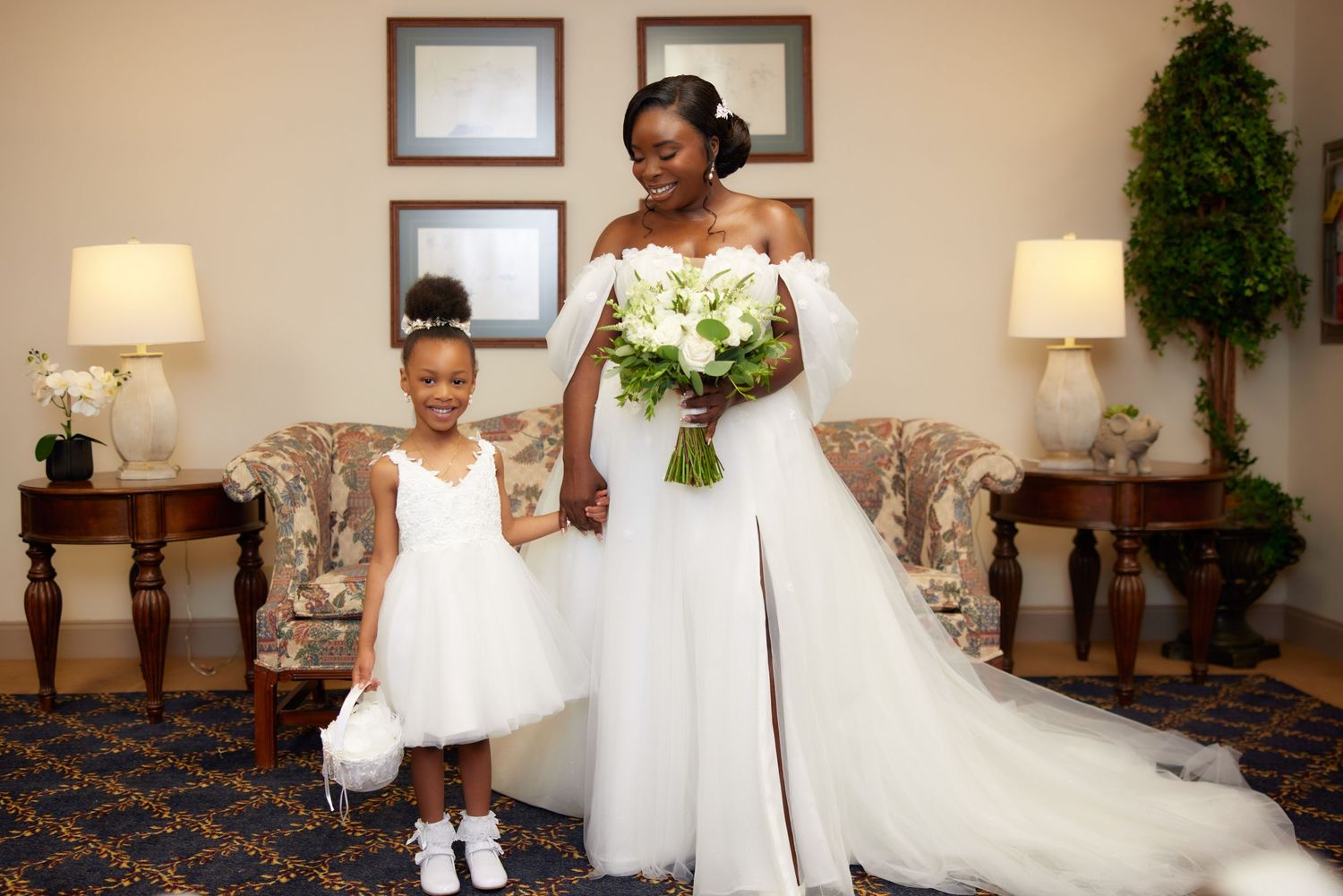 Two ring bearers in white outfits walk down a carpeted aisle during an elegant church wedding ceremony.
