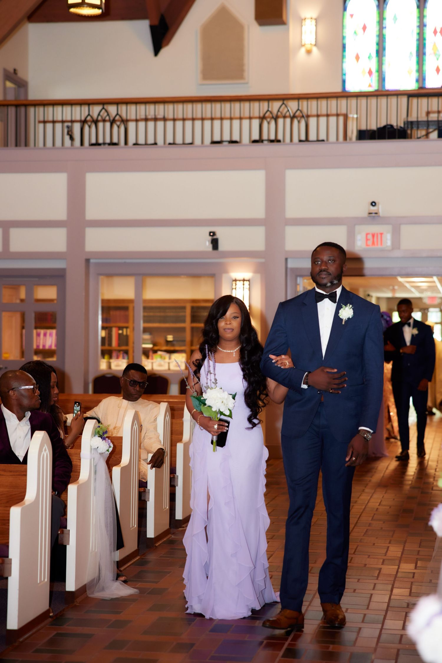 A elegant wedding ceremony in a chapel with white pews and beautiful lantern lighting decorating the interior.