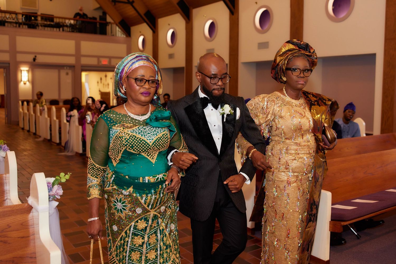 Wedding ceremony participants in formal attire stand at the altar of an elegant church sanctuary.