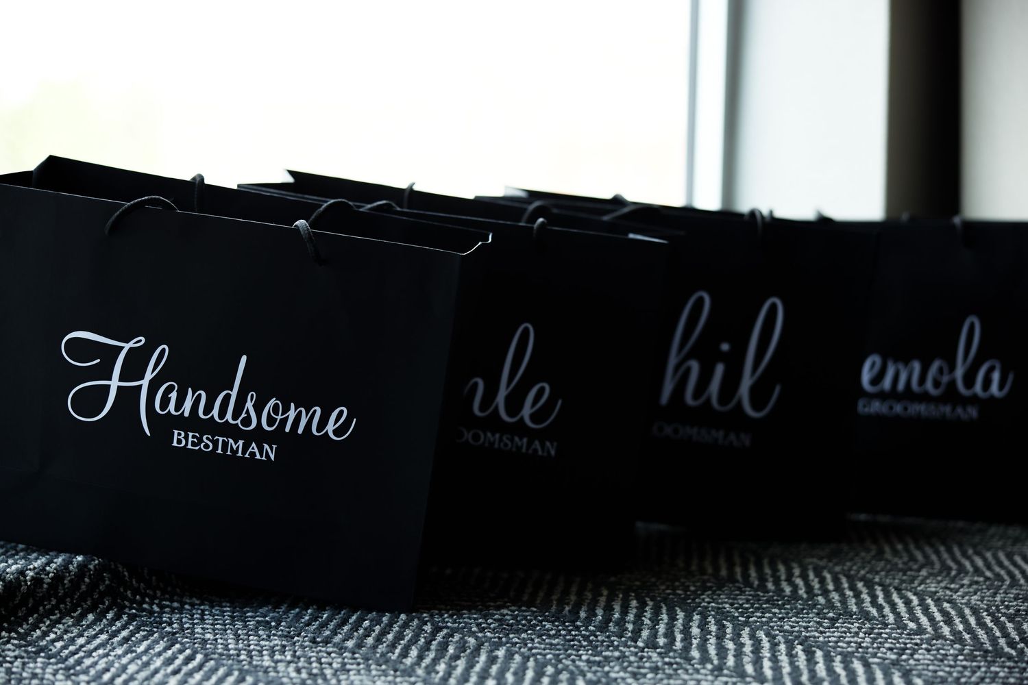 Close up view of black text branding on a textured gray surface showing elegant typography.