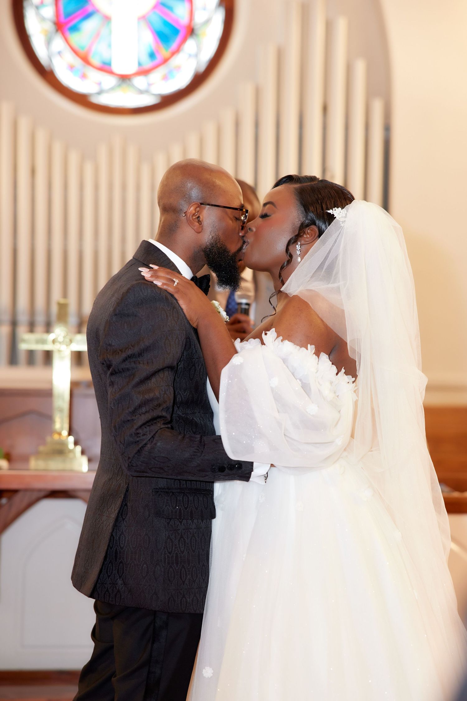 A romantic wedding kiss scene between newlyweds shown in a series of four sequential photos.