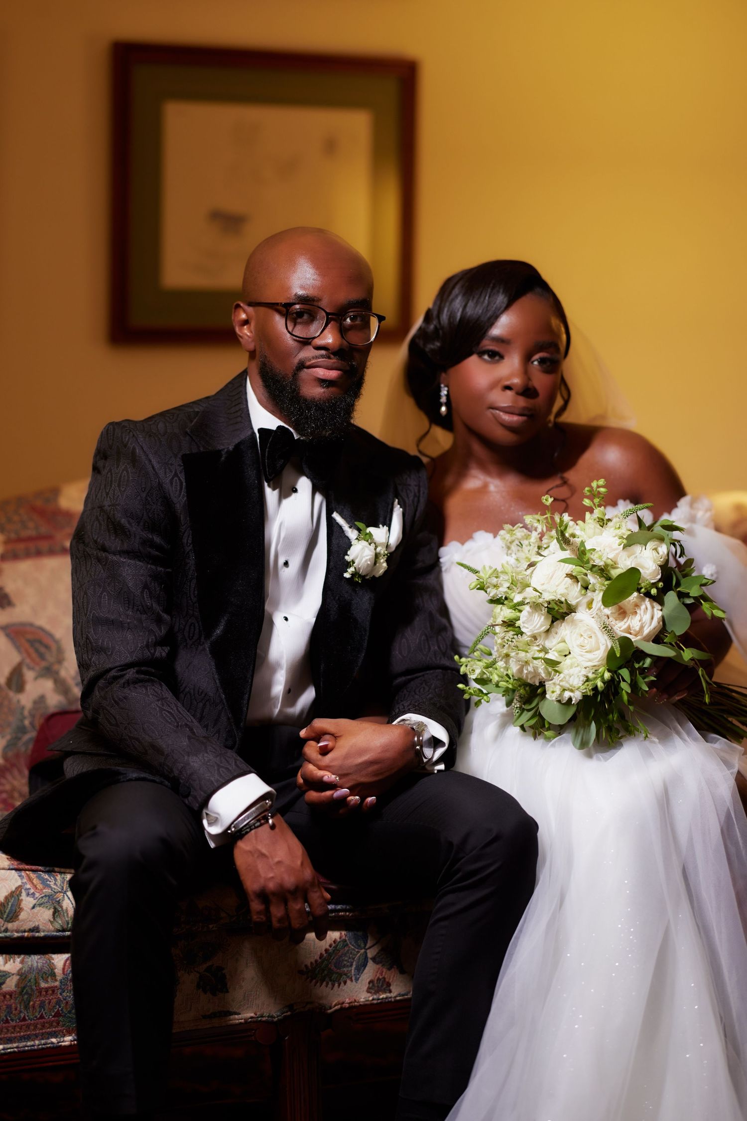 A bride and groom share an intimate moment while seated during their wedding celebration.