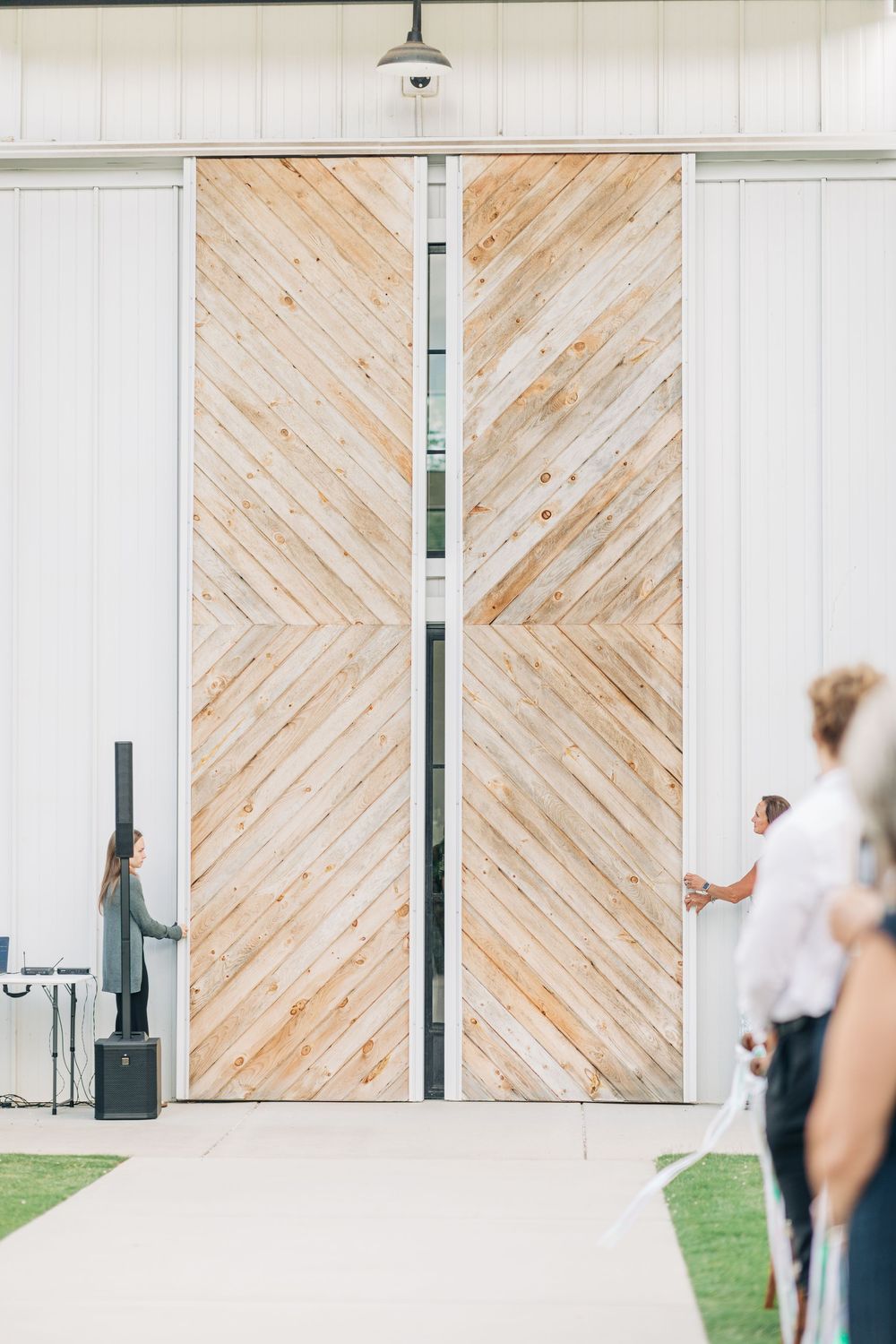 White modern barn wedding venue with diagonal wooden accent walls and large windows.