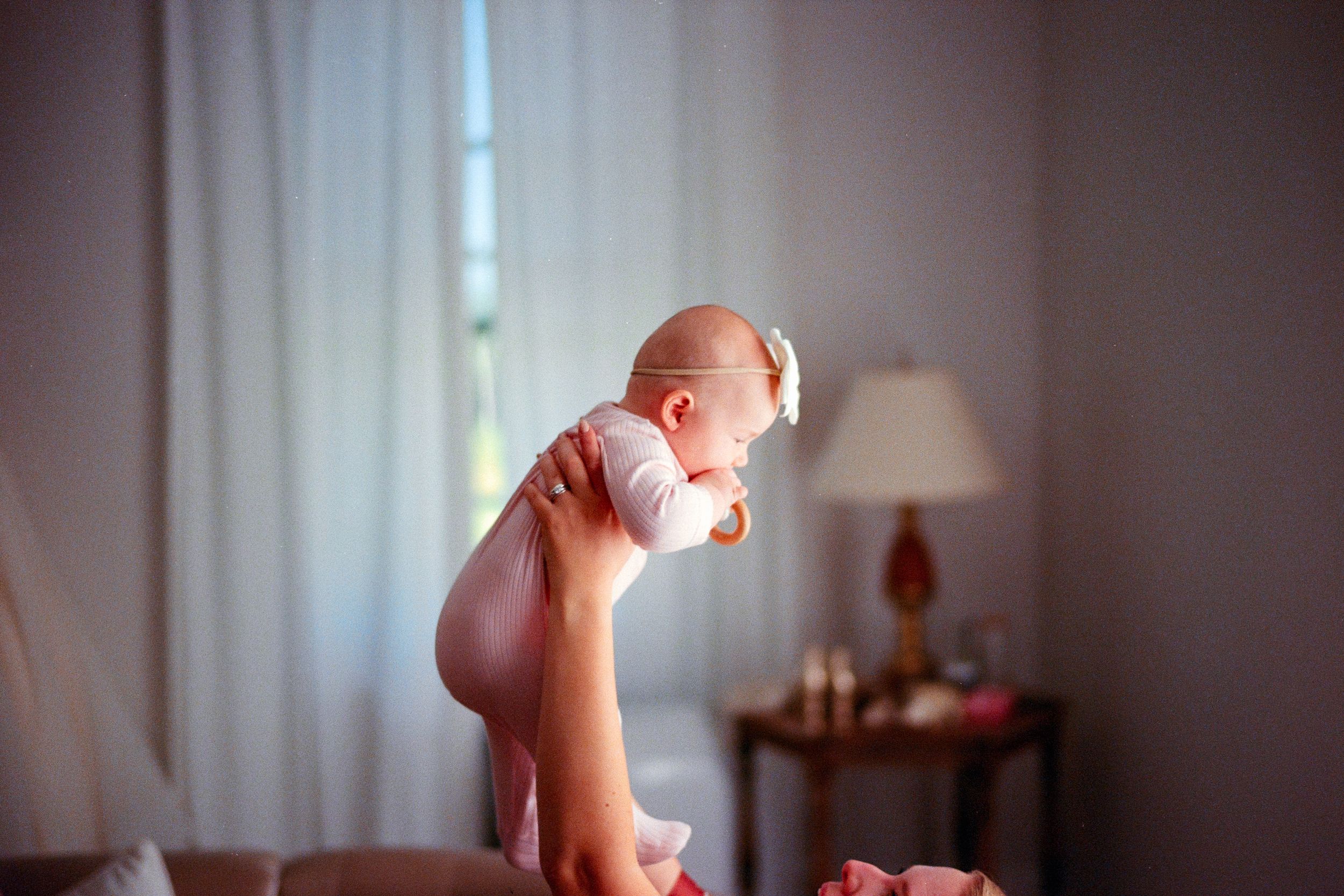 A sequence of photos showing a baby sitting and playing with bubbles near a window in soft natural light.
