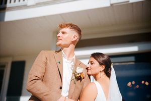 Newlyweds pose together outside on their wedding day with modern autumn styling.