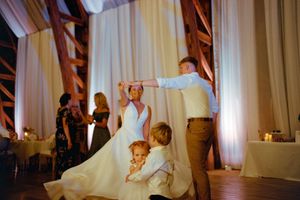 Multiple images show a couple performing their first dance at a wedding reception with white drapes in the background.