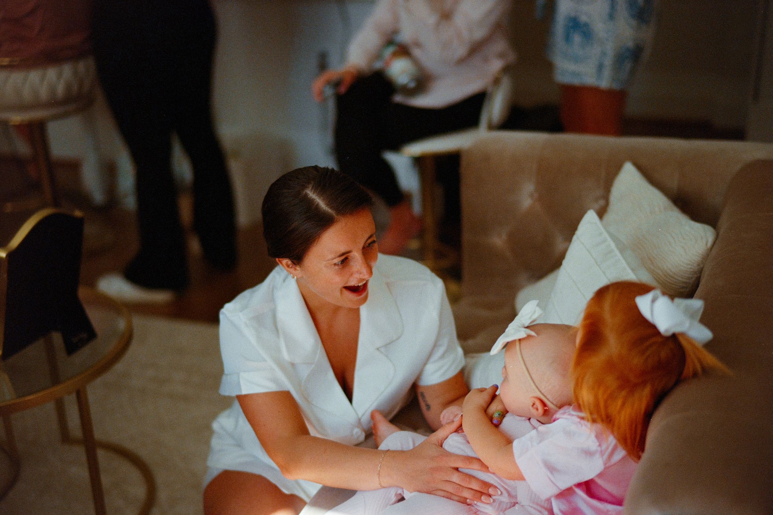 A series of tender moments during a baby bath time routine with white robes and towels in warm lighting.