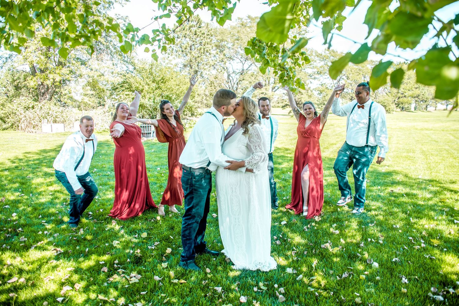 Group of people posing together in a sunny garden with white flowers.