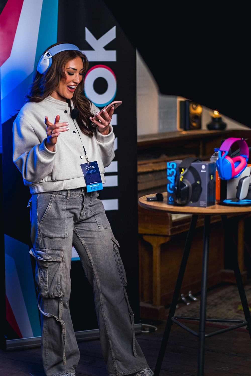 Presenter wearing grey cargo pants and white sweater speaking at a tech conference.