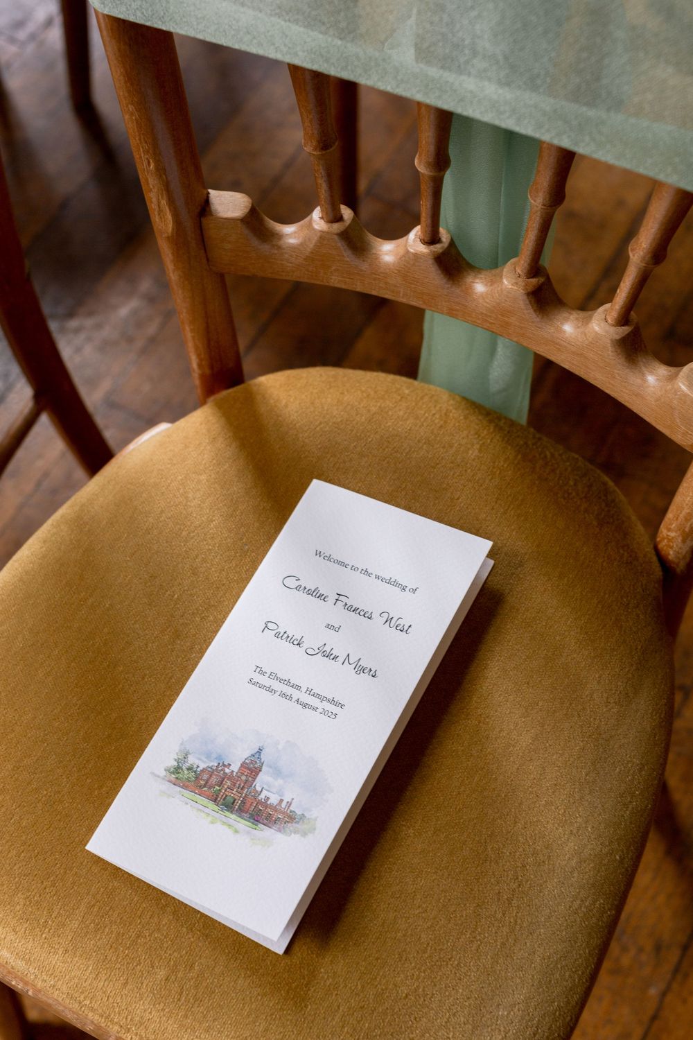 Wedding program rests on a vintage wooden chair with elegant details.
