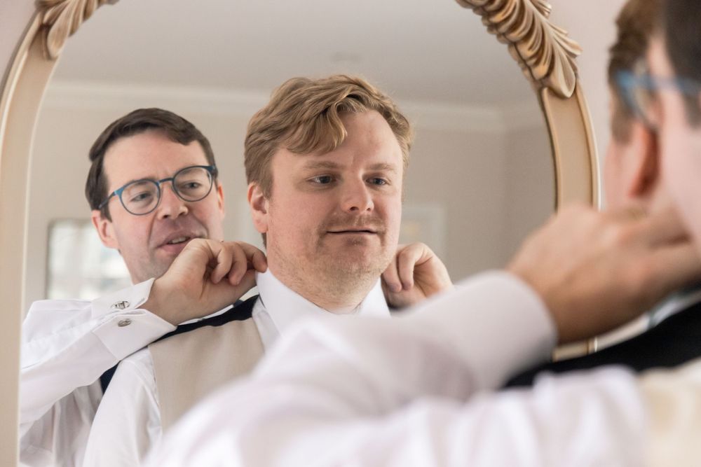 Groomsmen getting ready in formal attire and vests.