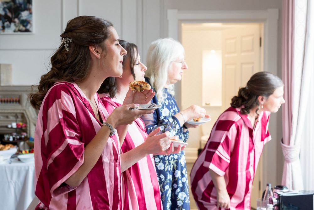 Wedding party celebrating in pink robes during pre-ceremony preparations.