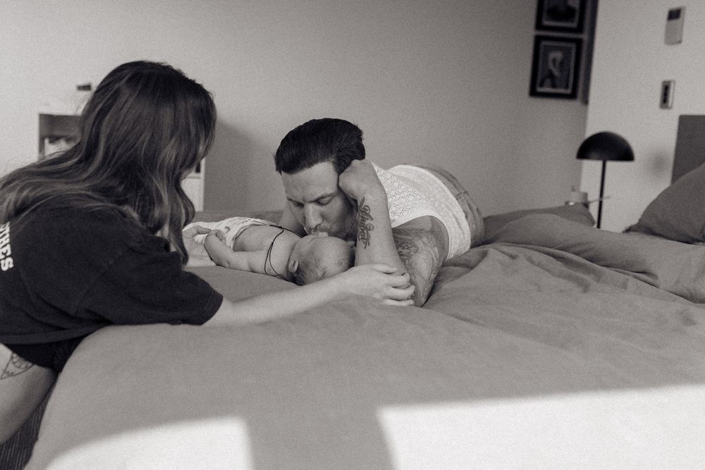 Couple sharing intimate moments in a minimalist bedroom setting.