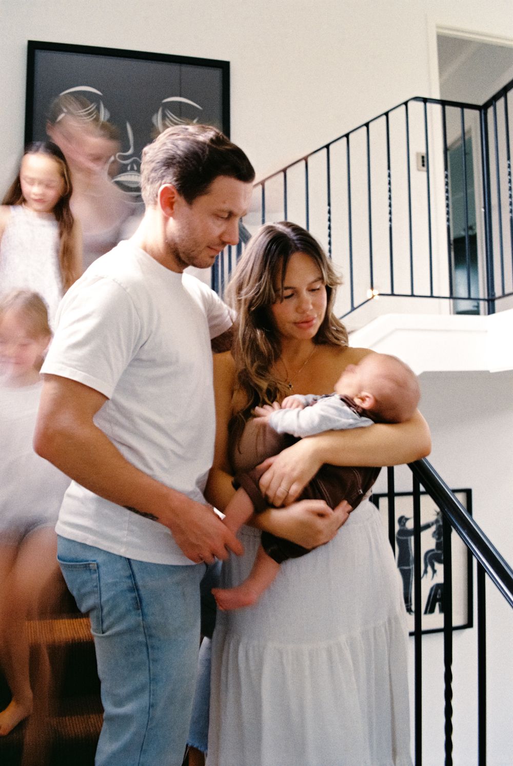 A family gathers on stairs in their modern home with natural light streaming in.