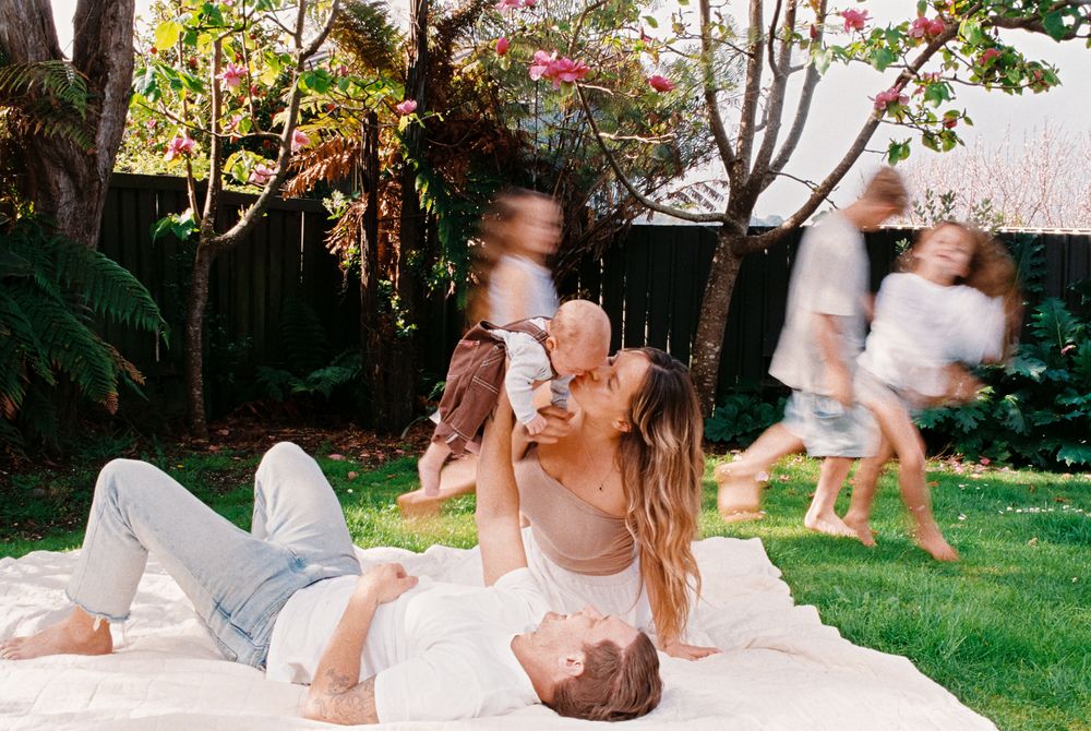 Playful moments captured in a sunlit garden with flying white fabric.