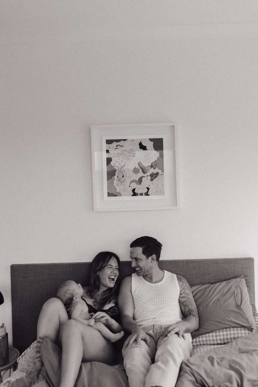 A black and white series of candid moments between a couple relaxing on a gray couch.