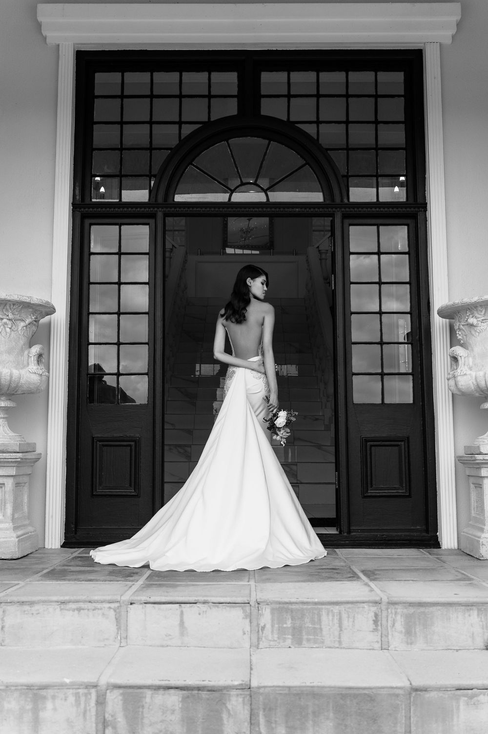 Black and white series of bridal photos featuring a classic strapless wedding dress on a grand porch entrance.