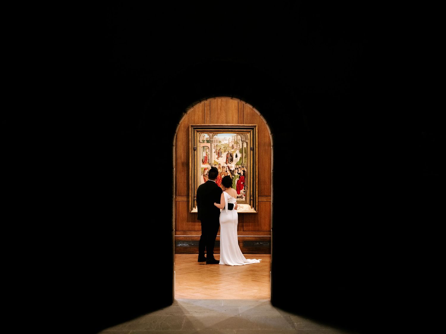 Wedding ceremony silhouettes framed through wooden doorways in warm lighting create dramatic entrance moments.