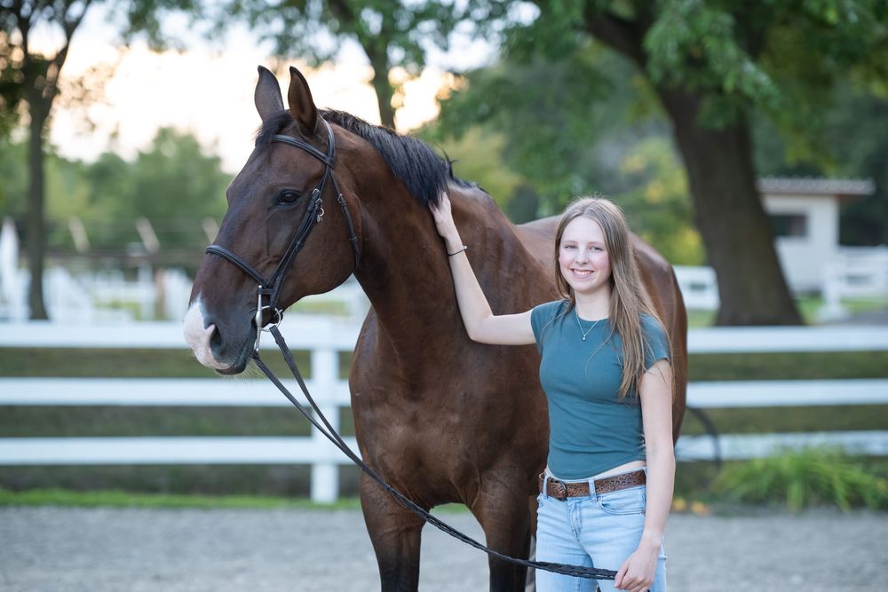 Brown horse and rider in casual attire pose for a series of outdoor photoshoot pictures by a white fence.