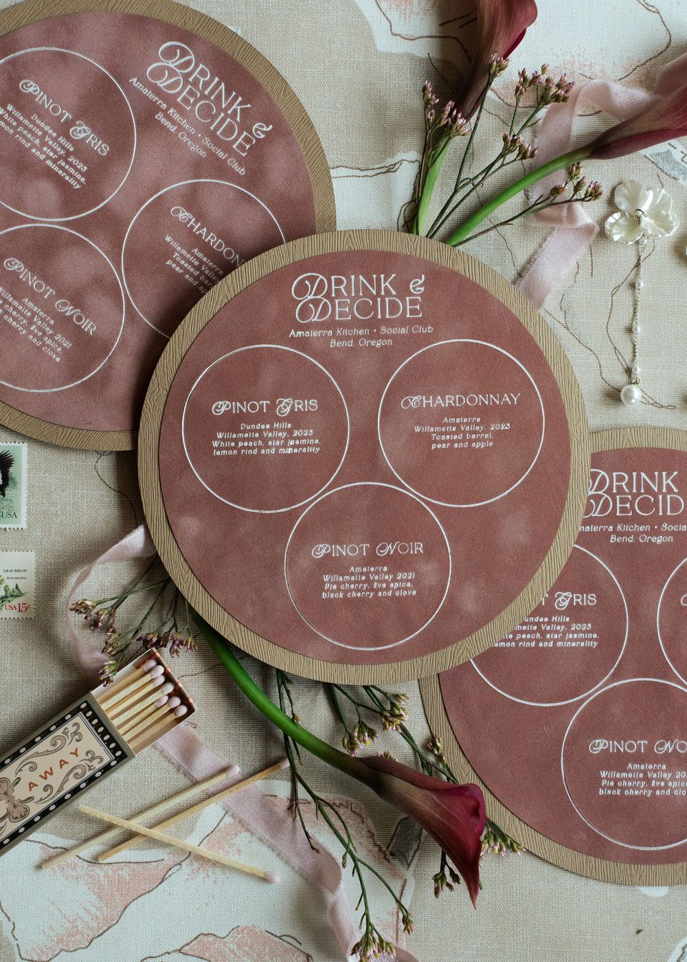 Circular wine menu cards for Drink & Decide at Amenita Kitchen, featuring Pinot Gris, Chardonnay, and Pinot Noir options.