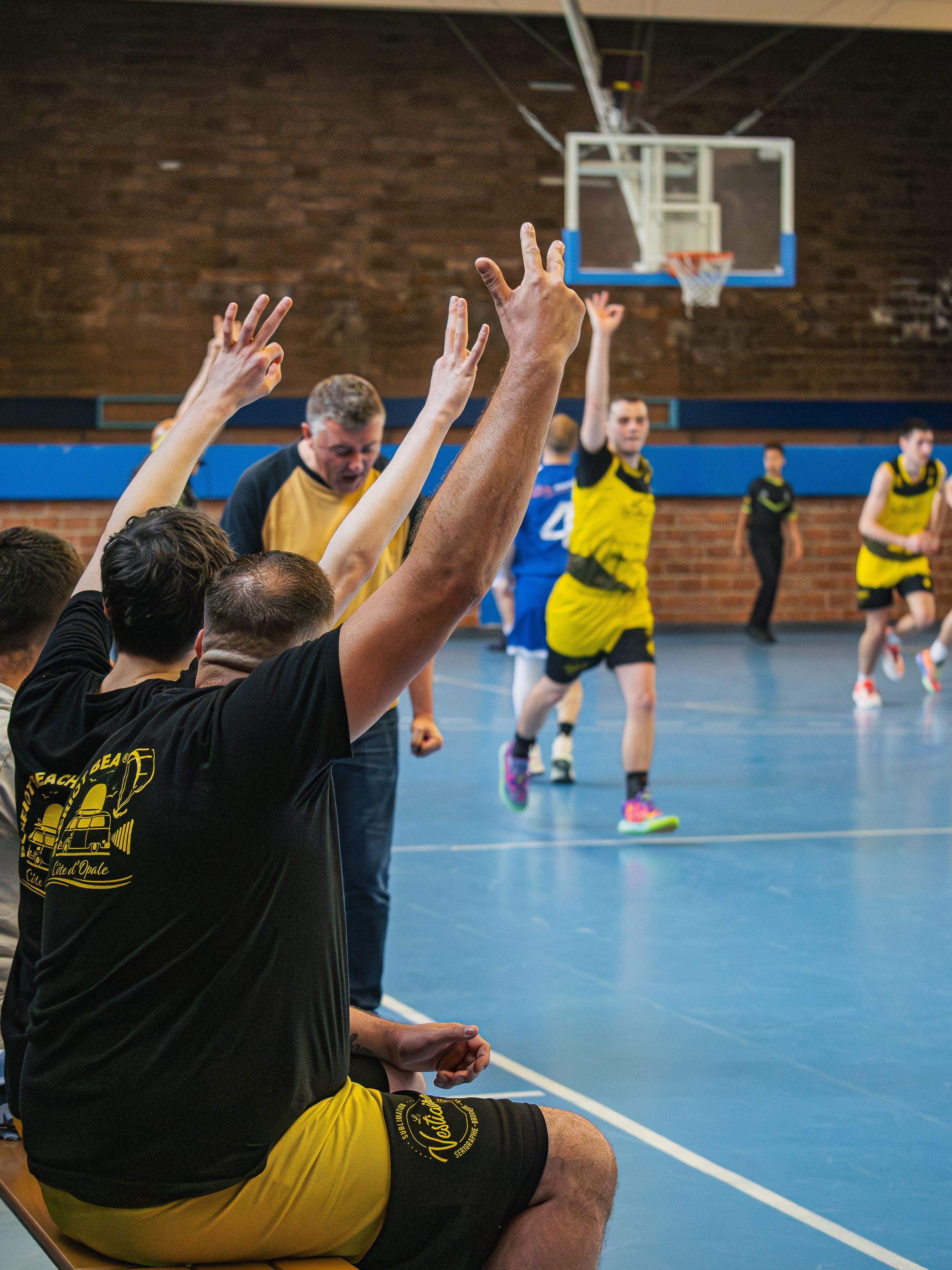 banc des remplaçants d'une équipe de basketball qui célèbre un 3 points inscrits par leur joueur