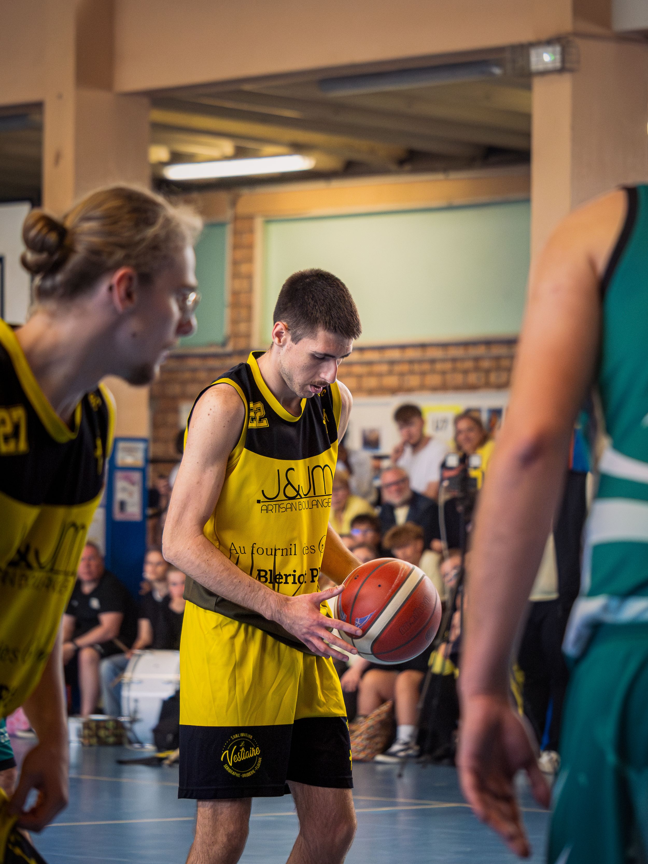 joueur de basketball qui tire un lancer franc pour son équipe les jaune et noir