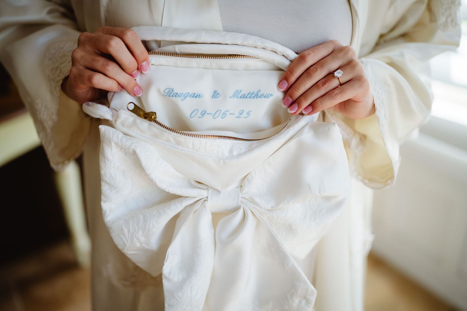 Close-up view of hands holding white porcelain bowls with traditional tea ceremony utensils.