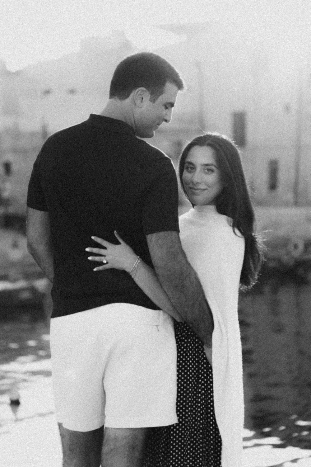 Romantic black and white photo sequence showing a couple embracing near a waterfront.