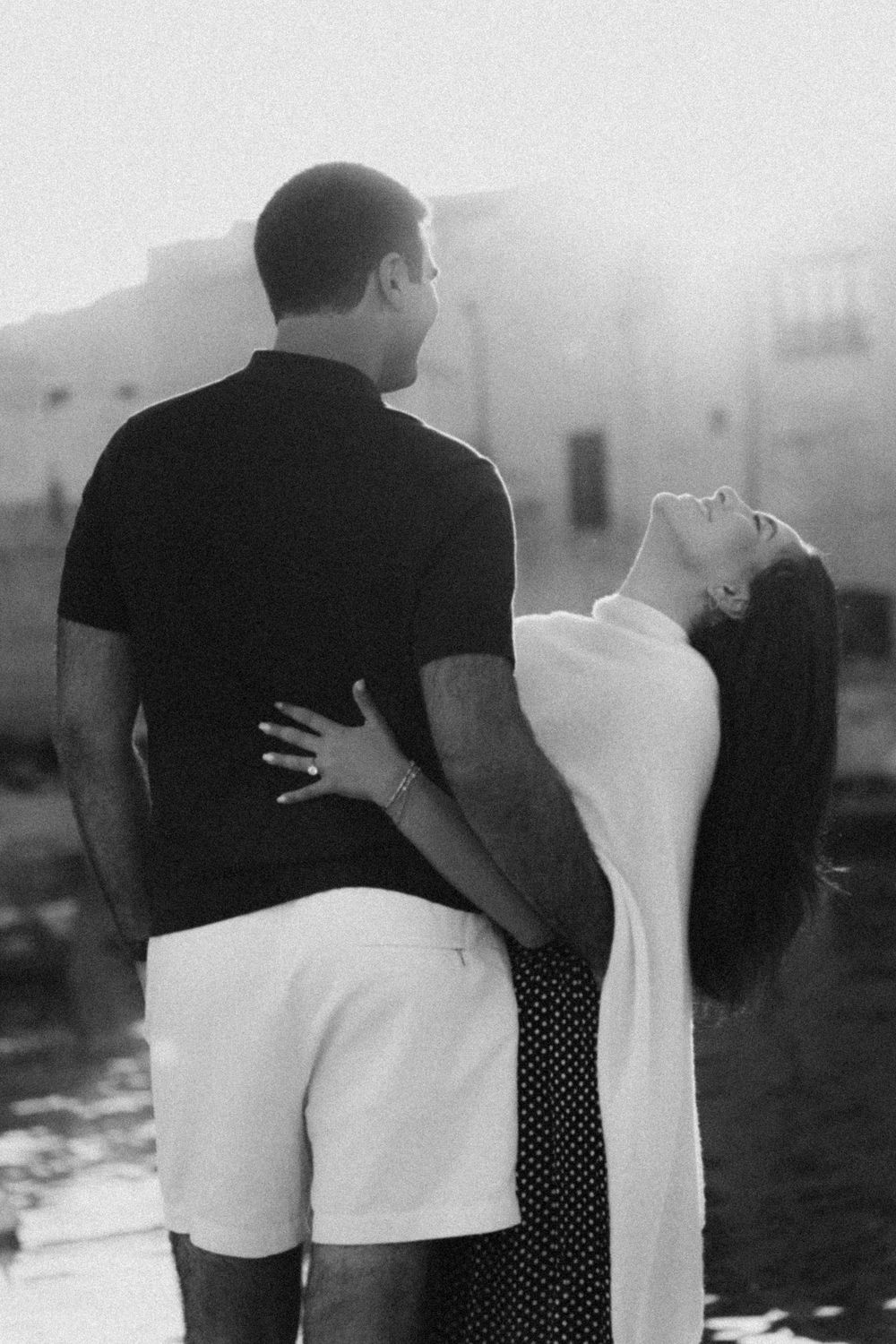 A series of romantic black and white photographs showing an intimate couple embracing against a blurry background.