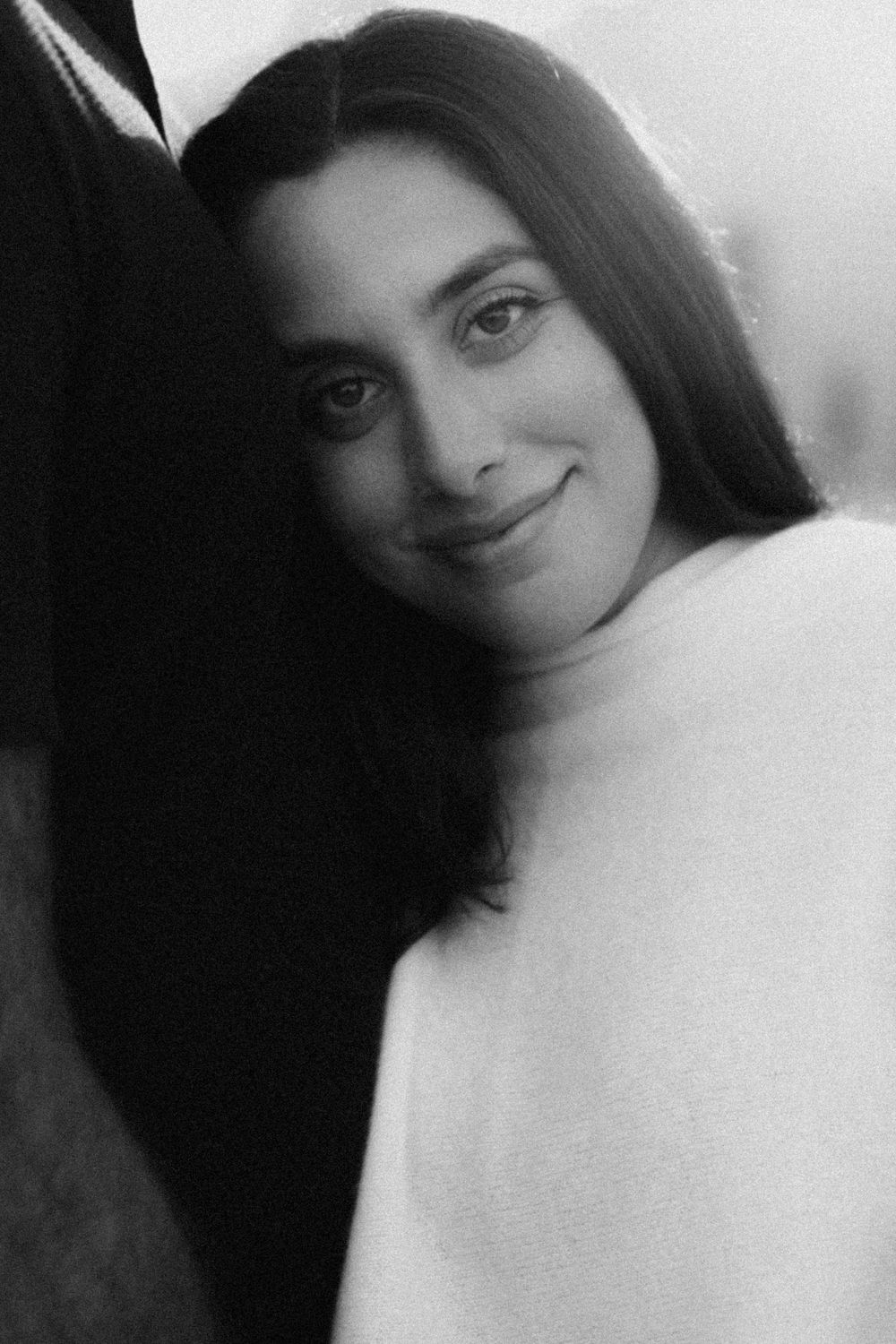 A black and white photo series showing intimate close-up portraits with gentle smiles and soft lighting.