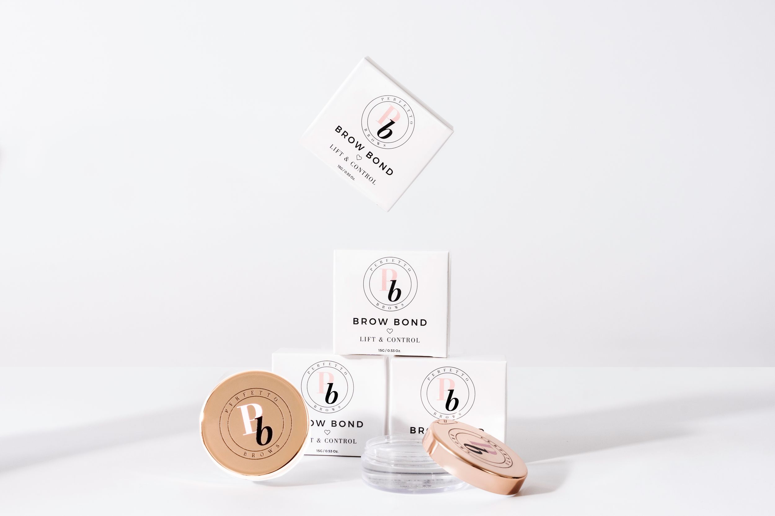 Minimalist white beauty product packaging with wooden lid containers and jars on a light background.
