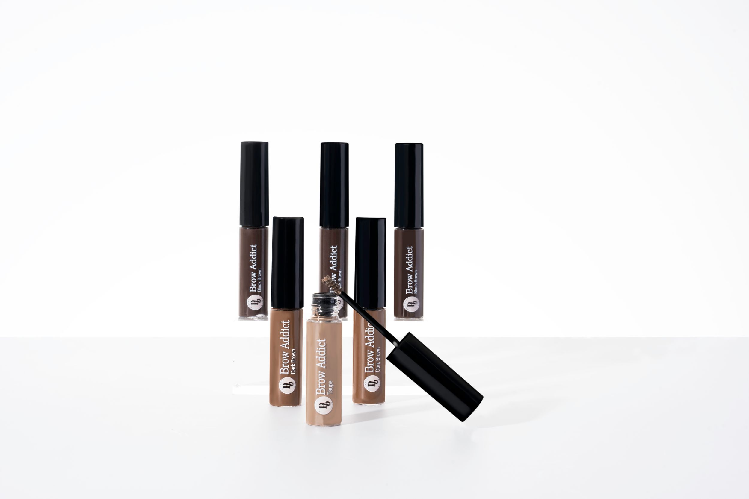 A row of matte liquid lipstick tubes in neutral shades displayed on a white background.