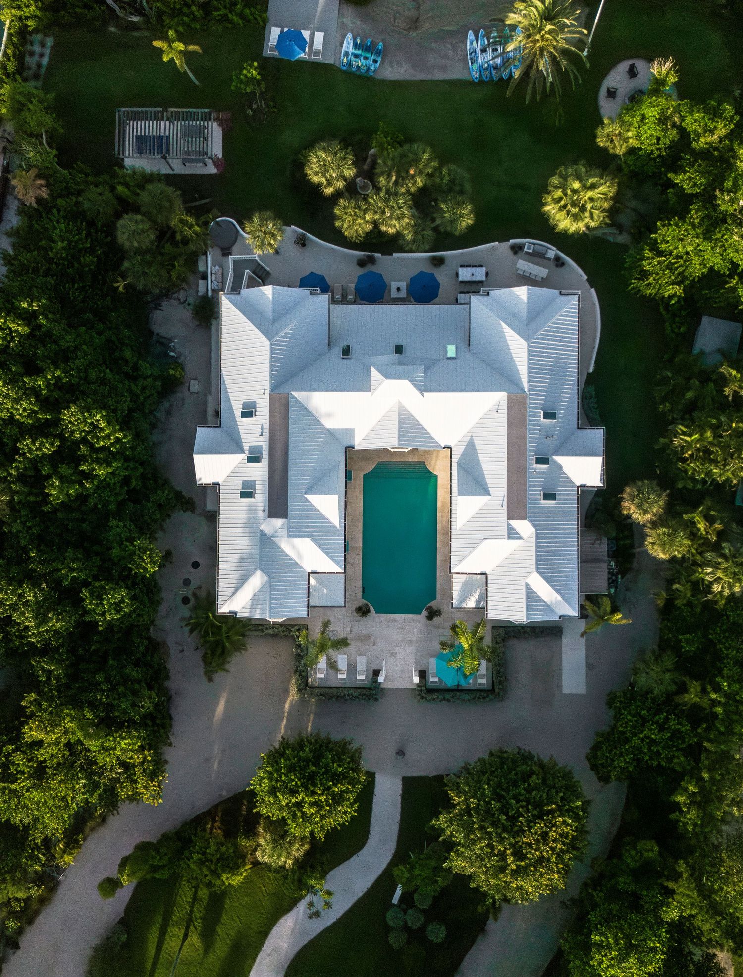 Drone shot of white vacation homes surrounded by lush tropical landscaping.