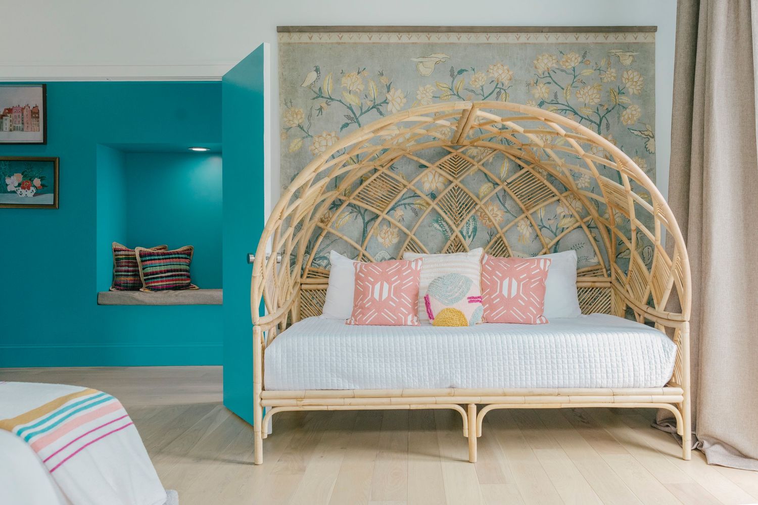 Coastal-themed bedroom with turquoise walls, rattan headboard, and beach-inspired decor.