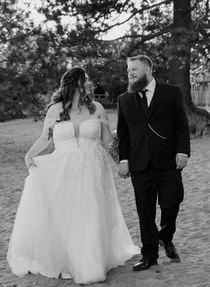 A romantic black and white beach wedding photoshoot series showing a couple in wedding attire walking together on sandy dunes.