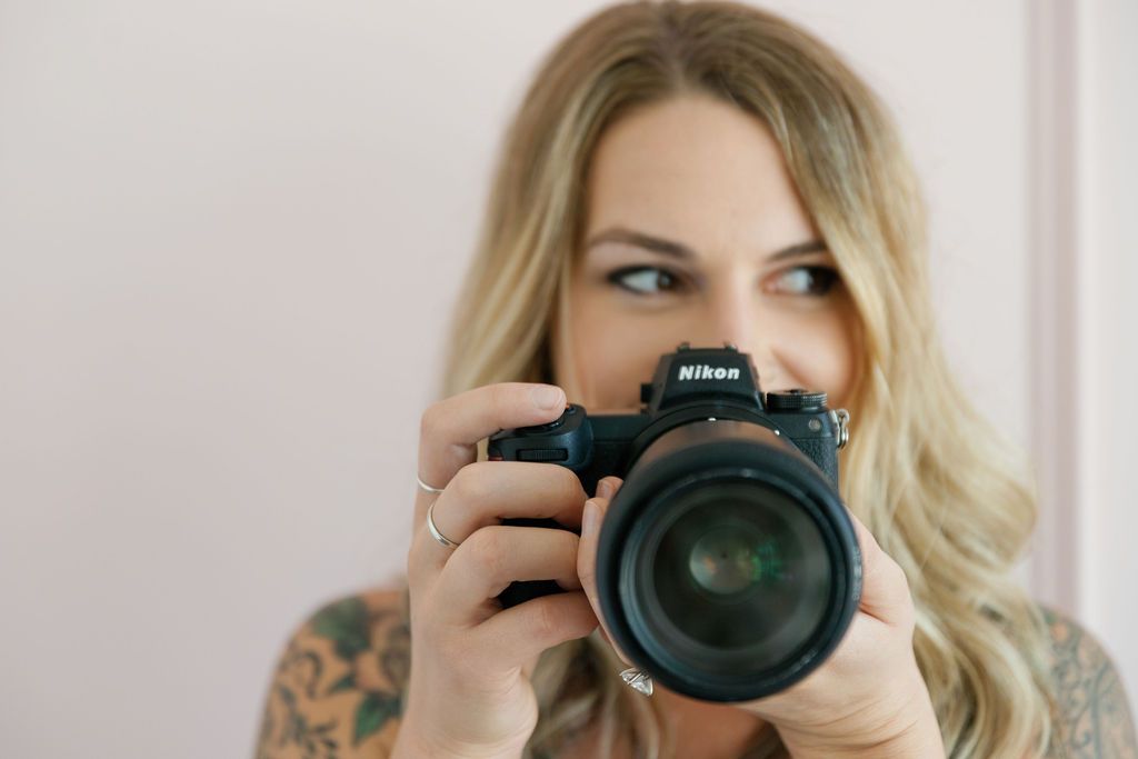 Photographer with blonde hair holding professional camera equipment in six similar poses against white background.