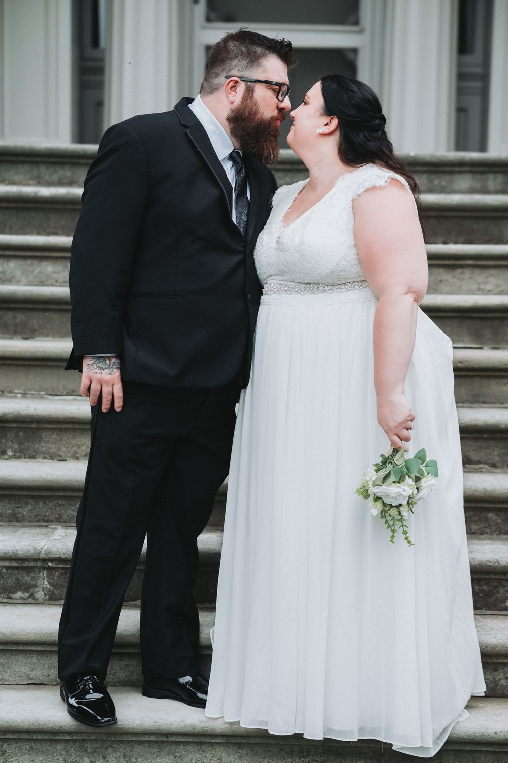 A romantic moment between newlyweds on grand stone steps.