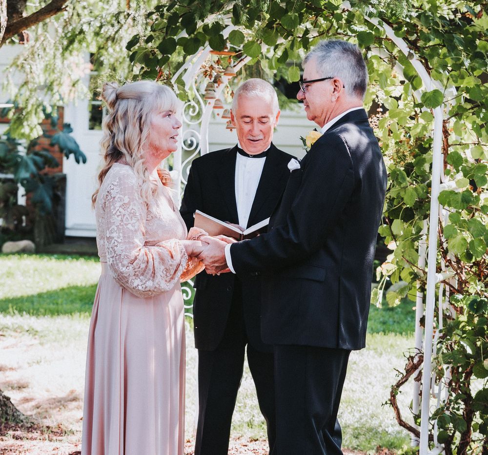 Outdoor wedding ceremony with couples exchanging vows under natural greenery.