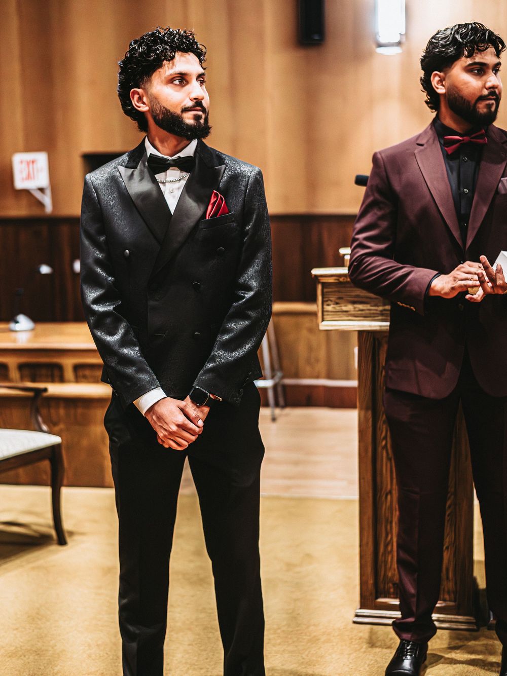 Group of people in formal attire standing in a church interior.