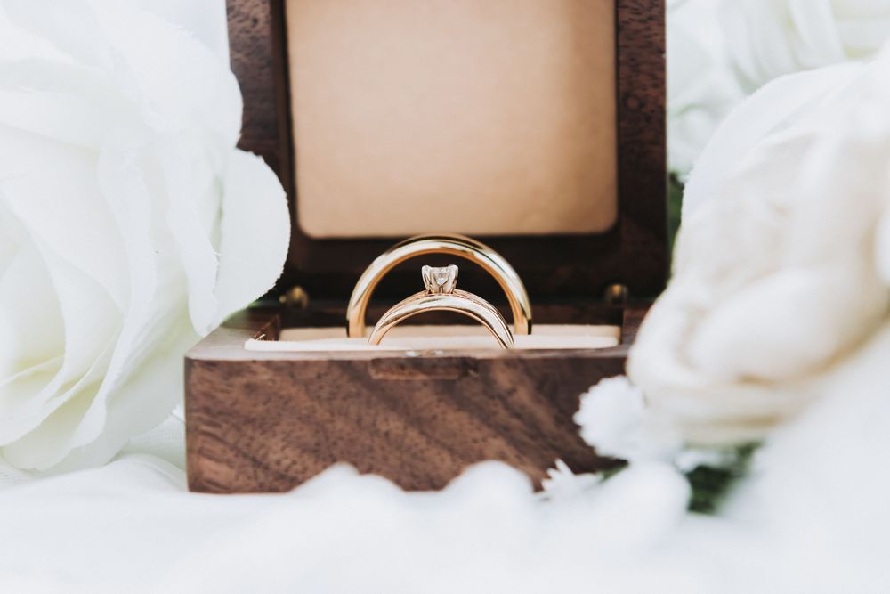 Elegant wedding rings displayed on a textured brown surface with soft lighting.