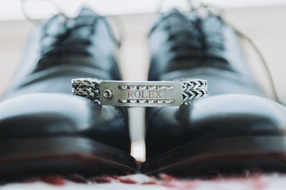 Black formal dress shoes arranged in a row on a reflective surface.