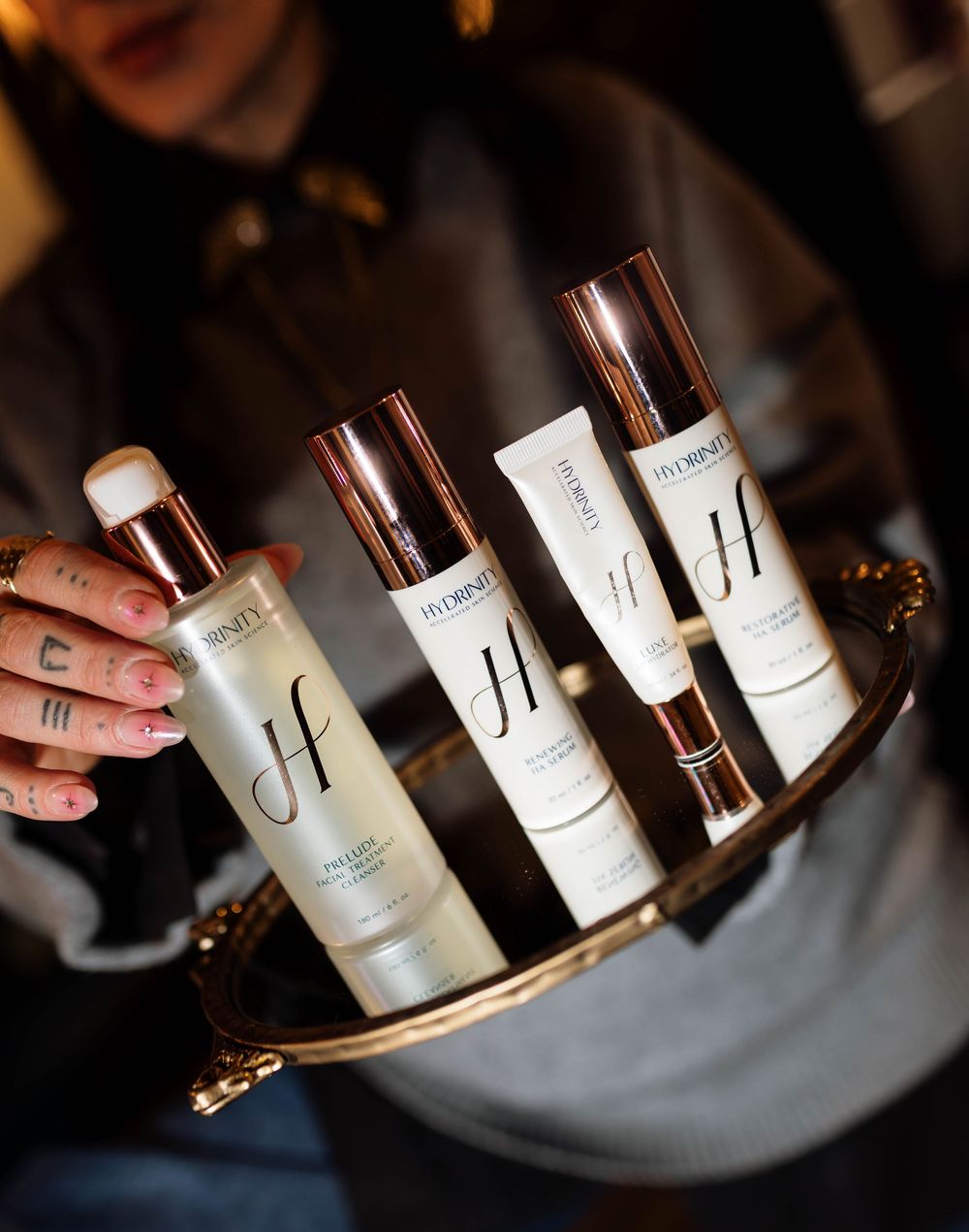 Elegant skincare product bottles arranged on a dark reflective surface.