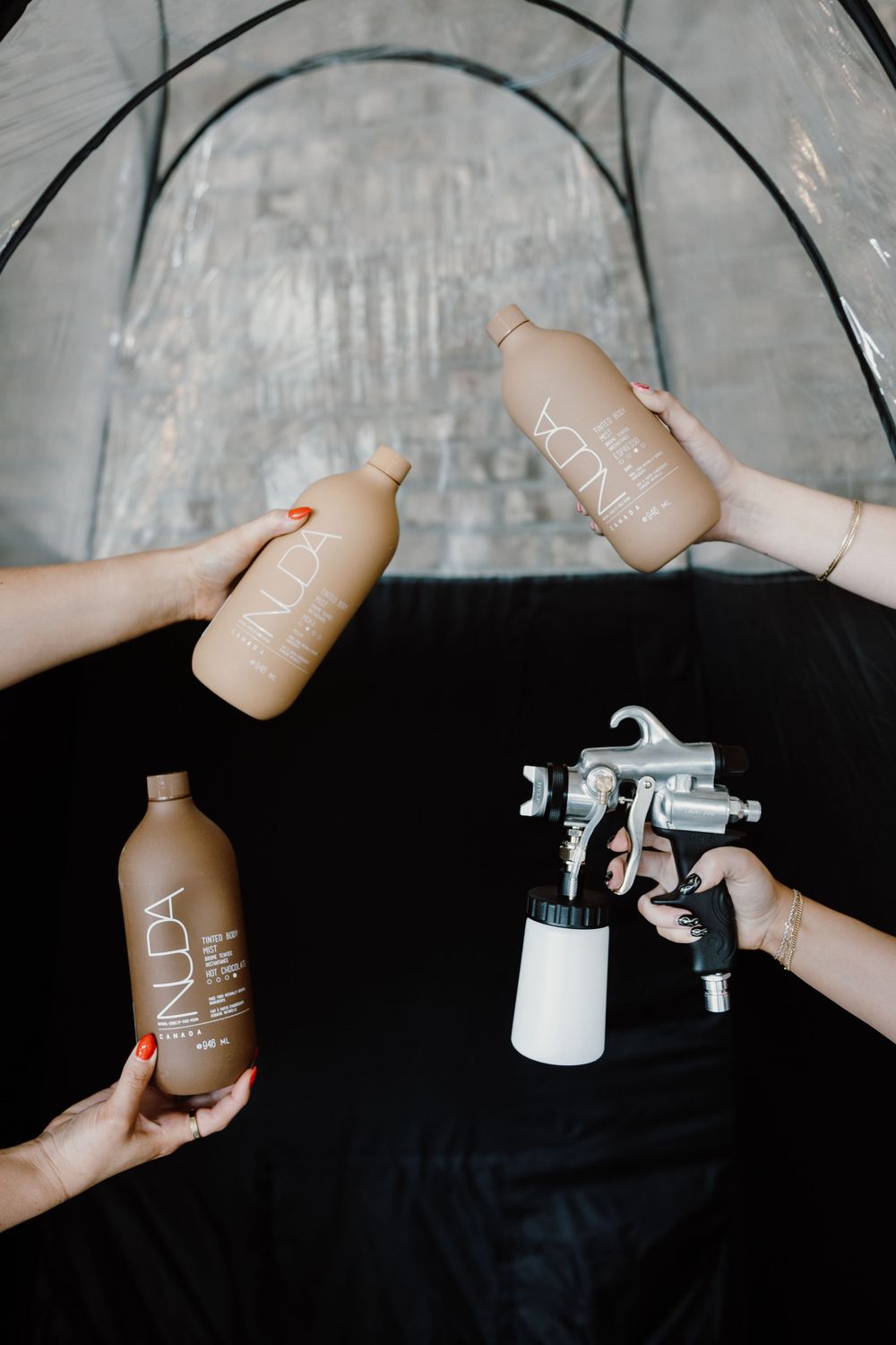Sequence of hands demonstrating the application of a beauty product against a dark background.