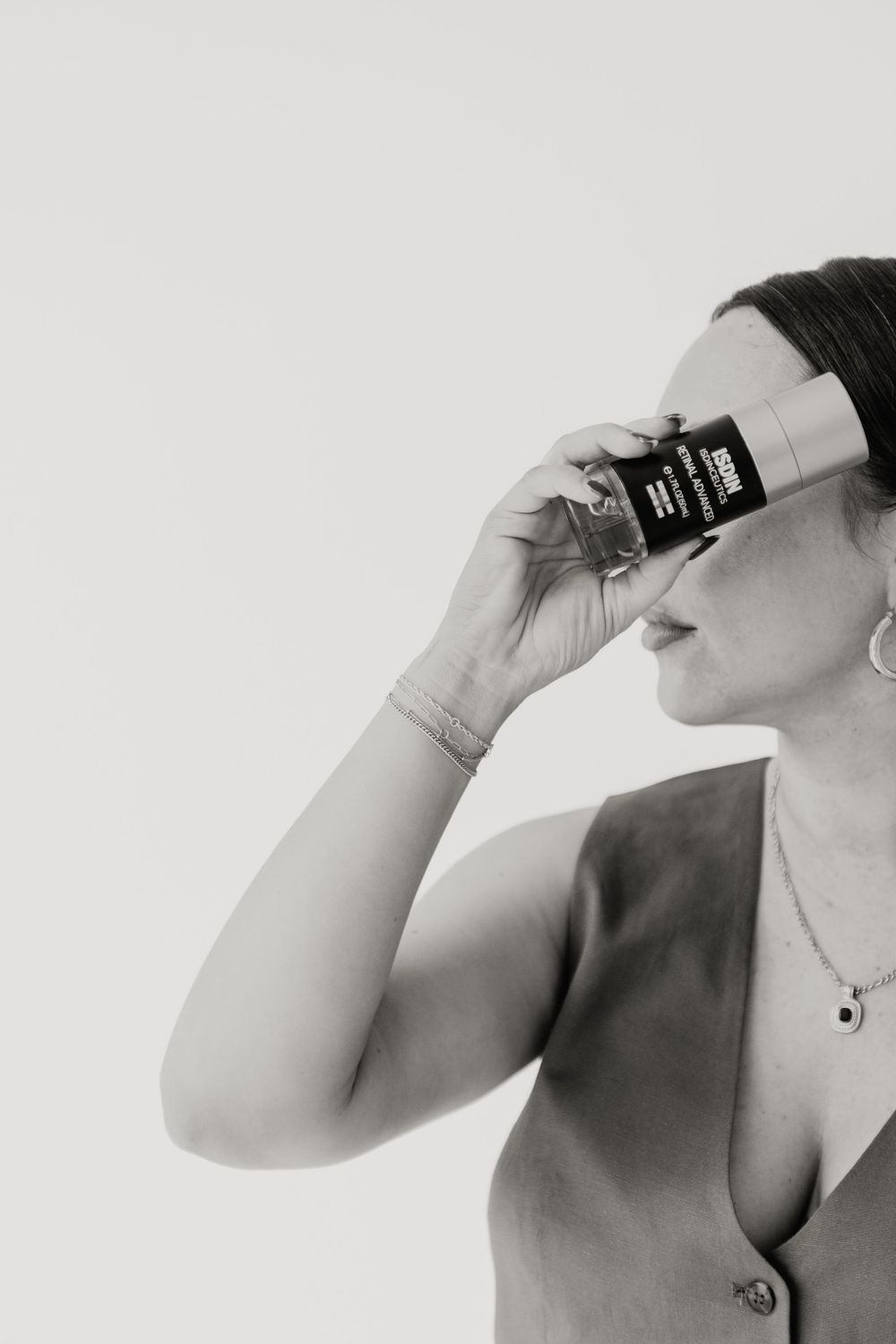 Close-up black and white photo showing someone drinking from a glass against a light background.
