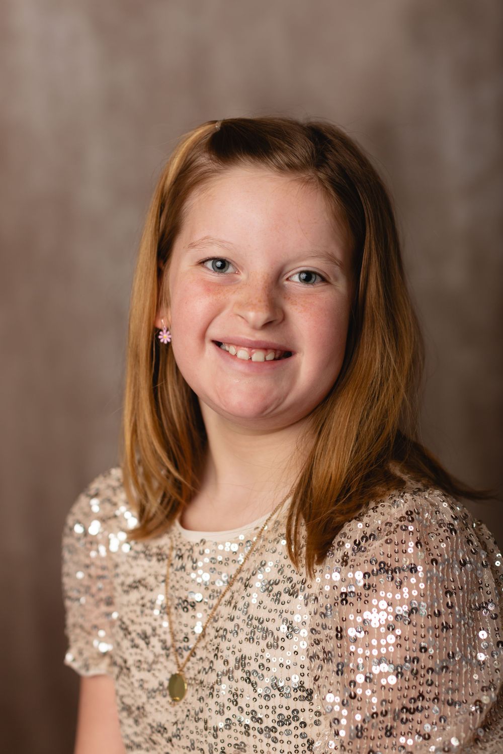 Homeschool child in casual outfit, smiling for a simple school portrait on a beige background